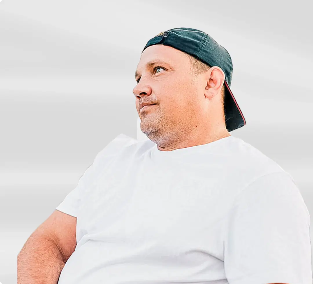 Man in white shirt and backward cap looking to the side, representing a health journey testimonial